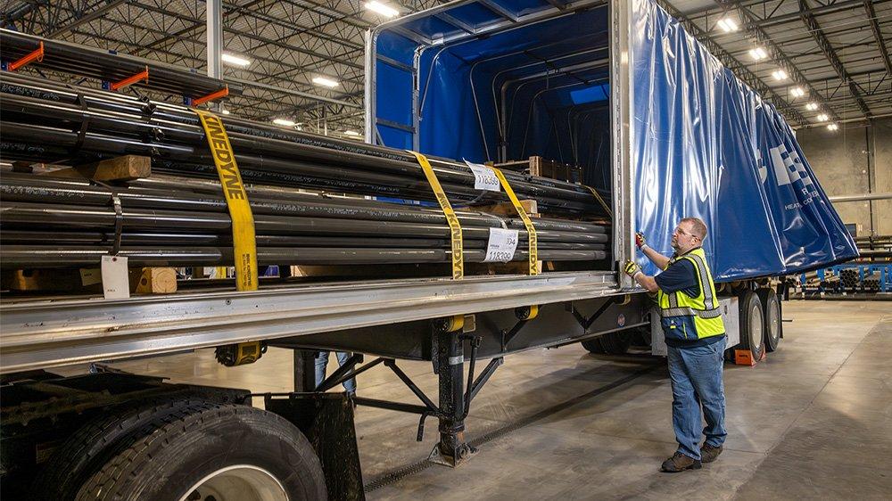 In a Ferguson fabrication facility, bundled and tagged pipe is loaded into a semi-trailer.